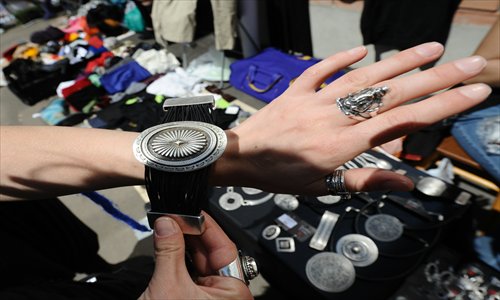 A customer tries on a secondhand bracelet at a local flea market. Photo: CFP