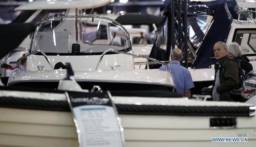 Visitors view yachts on display at the 58th London Boat Show, held at the ExCeL Exhibition and Convention Centre in London, Jan. 14, 2013. The 58th London Boat Show showcases, demonstrates and sells maritime equipments including luxury yachts, dinghies, boating equipment and clothing with interactive sections and features attractions devoted to boating until Jan. 20, 2013. (Xinhua/Wang Lili) 