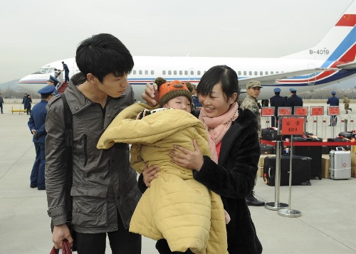 &nbsp;Peng Weiping (R front), a deputy to the 12th National People's Congress (NPC) from east China's Anhui Province, is seen with her baby and husband at the airport upon their arrival in Beijing, capital of China, March 2, 2013. The first session of 12th NPC is scheduled to open in Beijing on March 5. (Xinhua/Xie Huanchi) 
