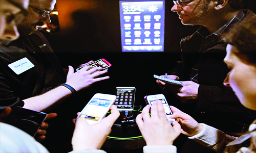 People photograph the HTC One smartphone (center), on display at its launch event in New York on Tuesday. Taiwan's HTC launched its newest smartphone simultaneously in London and New York. The phone will go on sale in March to compete with HTC's South Korean rivals Samsung and LG. Photo: CFP