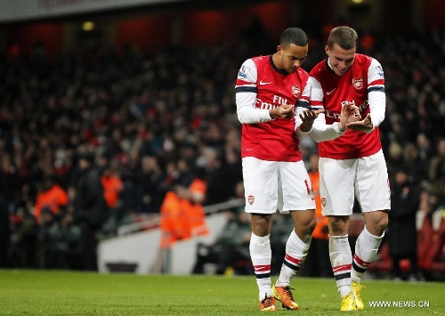 Theo Walcott (L) of Arsenal celebrates scoring with teammate Lukas Podolski during the English Premier League football match between Arsenal and West Ham United at the Emirates Stadium in London, Britain, on Jan. 23, 2013. Arsenal won 5-1.(Xinhua/Wang Lili)&nbsp; 