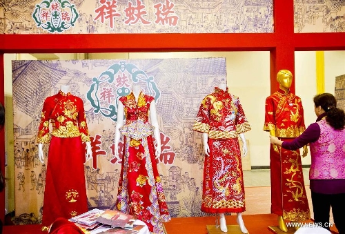 A working staff puts wedding dresses on models during the 2013 Beijing Wedding Expo in Beijing, capital of China, March 1, 2013. The three-day event kicked off on Friday. (Xinhua/Wang Jingsheng) 