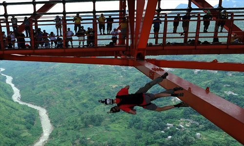 Two  parachutists jump off the Balinghe Bridge in Anshun, southwest China's Guizhou Province, on Saturday. Thirty parachutists from 15 countries and regions took part in the bridge-jumping competition. The Balinghe Bridge is more than 300 meters above the river. Photo: IC