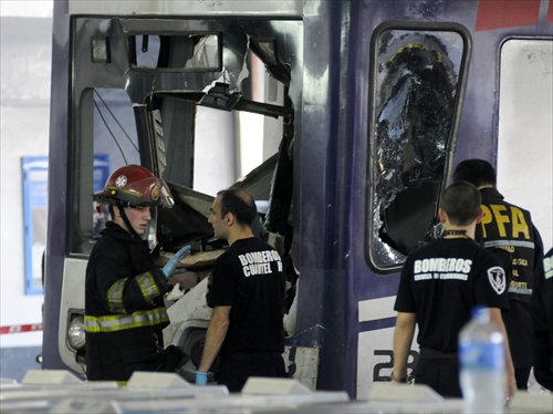 Firefighters inspect a commuter train that apparently failed to stop and crashed at the end of the line at the Once railway terminal in Buenos Aires, on Sunday. Dozens were hurt, five seriously. Officials said they could not immediately determine the cause of the crash. Photo: CFP