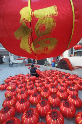 A villager makes a red lantern at a workshop in Yangzhao Village, a lantern production base in Jishan County of Yuncheng City, north China's Shanxi Province, Jan. 12, 2013. Chinese people traditionally hang red lanterns to greet and celebrate the Spring Festival, which falls on Feb. 10 this year. (Xinhua/Gao Xinsheng)&nbsp;