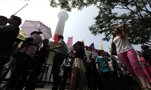 Visitors wait in line near the Oriental Pearl TV Tower in Shanghai on Sunday, marking China Tourism Day. Fifty-one attractions in the city offered half-price admission to visitors. The tower had received 13,000 visitors by Sunday afternoon. Photo: Cai Xianmin/GT