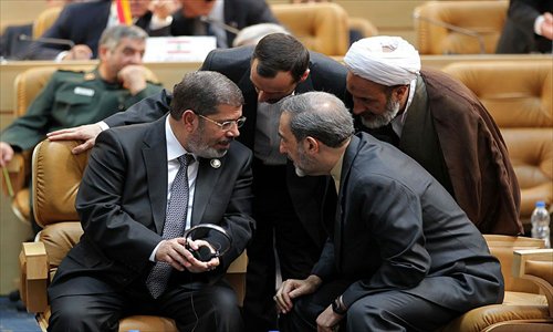 Egyptian President Mohamed Morsi (left) speaking with former Iranian foreign minister, Ali Akbar Velayati (right) as they attend the opening of the Non-Alligned Movement summit in Tehran on Thursday. Photo: AFP  