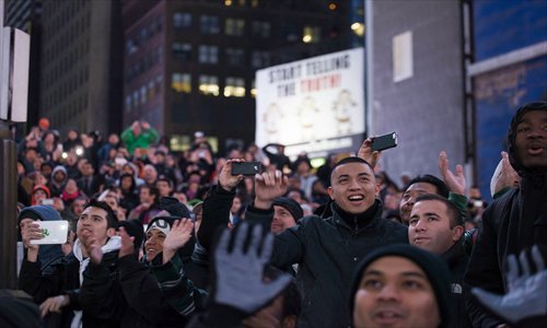Spectators gather and use their smartphones to document the release of Samsung's Galaxy S4 smartphone in Times Square in New York on March 14.Photo: CFP