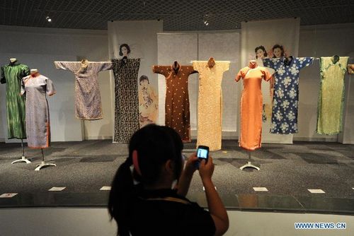 A visitor looks at cheongsams, a traditional Chinese women's dress also known as mandarin gown or Qipao, at China Silk Museum in Hangzhou, capital of East China's Zhejiang Province, June 13, 2012. More than 110 cheongsams were displayed at China Silk Museum in Hangzhou from June 11, 2012. Photo: Xinhua