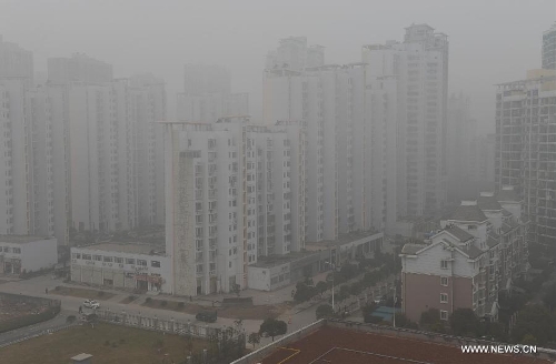 &nbsp;&nbsp;Fog-shrouded buildings are seen in the Honggutan New District of Nanchang City, capital of east China's Jiangxi Province, Jan. 12, 2013. A fog hit many parts of Jiangxi on Saturday. (Xinhua/Song Zhenping)&nbsp; 