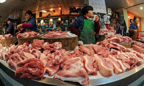 A meat seller wait for customers at a market in Hangzhou, capital of east China's Zhejiang Province, December 9, 2012. China's consumer price index (CPI), a main gauge of inflation, grew 2 percent year on year in November, the National Bureau of Statistics announced Sunday. The inflation rate increased from a 33-month low of 1.7 percent in October as food prices increased. Photo: Xinhua