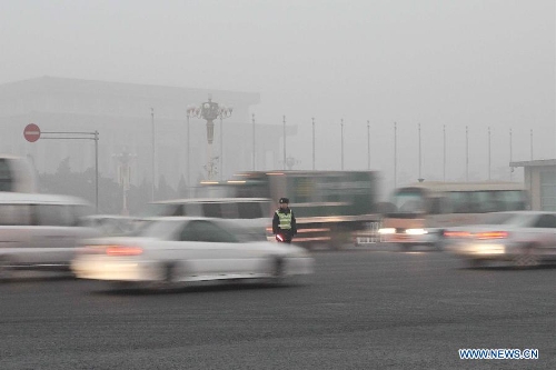 A policeman directs traffic amid fog and smog in Beijing, capital of China, Feb. 28, 2013. Beijing was again hit by heavy fog and smog on Feb. 28 morning. (Xinhua/Wang Yueling) 