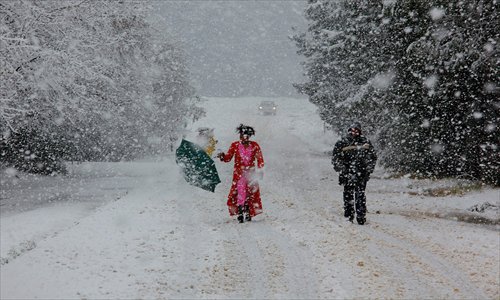Locals stroll as snow covers the street in Johannesburg. Photo: CFP