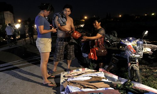 Zhang's wife buys secondhand clothes from a stall. Photo: Yang Hui/GT
