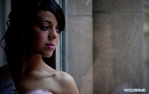 A 15-year-old girl looks out through a window as she gets ready to participate in the mass Quinceanera Party, in Mexico City, capital of Mexico, April 28, 2012. The Quinceanera Party is a Mexican tradition marking the transition from childhood to adulthood. A massive party was organized in Mexico City Saturday to celebrate Quinceanera for girls with limited economic resources. Photo: Xinhua