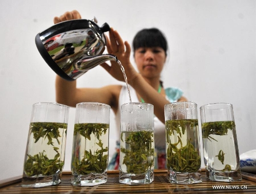 An exhibitor prepares tea for customers at the 6th Guangxi Nanning Spring Tea Fair in Nanning, capital of south China's Guangxi Zhuang Autonomous Region, April 29, 2013. The five-day fair kicked off on Sunday. (Xinhua/Lu Boan) 