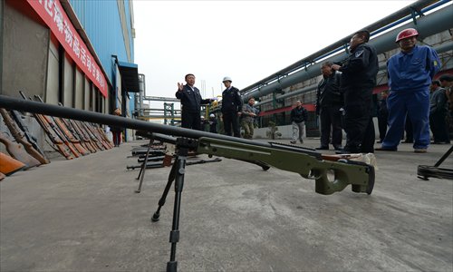 Officers with the Gansu Provincial Department of Public Security coordinate the destruction of 12,252 illegally made guns and 7,568 imitation guns at a steel refinery in Lanzhou on October 31. Photo: CFP