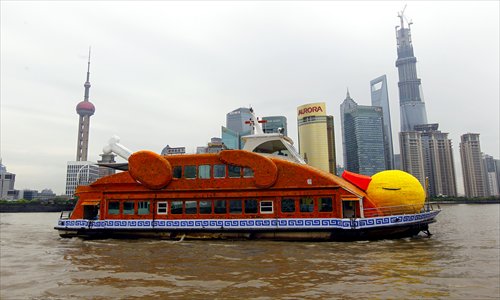 A ferry decorated as a yellow duck cruises the Huangpu River Monday. The purpose of the installation is to promote the Bund art project. Inside the ferry, poets do readings for passengers. The art project will also invite tourists to write verses that will later be compiled and redrafted into a poem. Photo: Yang Hui/GT