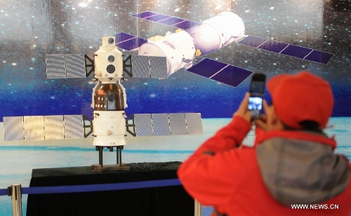 A visitor takes photo during the China's Space Exhibition in Hebei Museum in Shijiazhuang, capital of north China's Hebei Province, April 1, 2013. The exhibition which will last till April 7 included the display of space carriers, rocket-launcher models of the Long March series, paintings and photos related to aerospace. (Xinhua/Wang Xiao)&nbsp; 