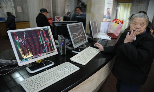An elderly investor looks away from the screen showing stock prices at a securities exchange in Shanghai on Friday. Chinese shares were down 0.17 percent in early trading, tracking overnight falls in US and European stocks, a day after falling over three percent due to worries of tighter regulation of the property market, dealers said. Photo: AFP