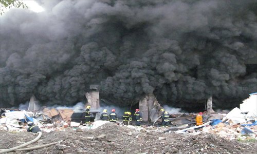 Firefighters work to put out a blaze at Shanghai Intco Industries Co Ltd in Fengxian district Tuesday. Nine workers were injured. Officials suspect the fire was caused by a violation of production rules. It took 156 firefighters around six hours to extinguish the fire. Photo: IC