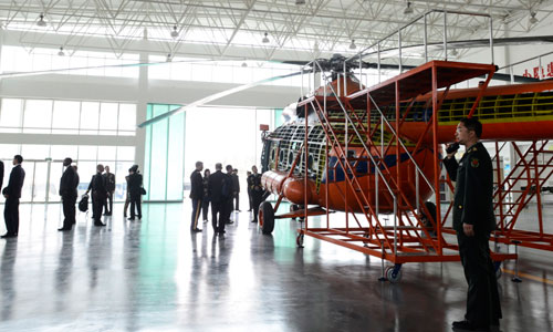 Dempsey inspects a helicopter simulator during his tour of a Chinese army aviation base.