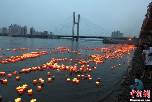 Lanterns float on the Song Hua River. 300 people set 14630 river lanterns on the Songhua River in Ji Lin Province on July 7, 2013, creating a new Guinness World Record. (Photo: Xinhua/Chinanews.com)