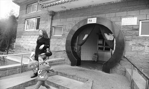 A mother and her daughter walk out of a public toilet near Guomao Bridge Sunday. The toilet is treated with new deodorizers. Photo: Li Hao/GT