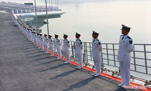 Military officers stand onboard China's aircraft carrier 