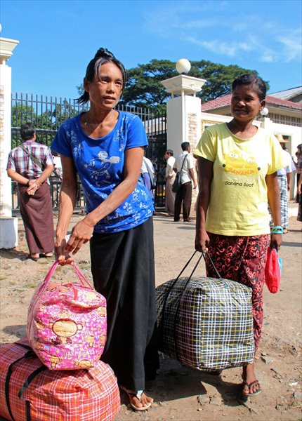 Myanmar prisoners carry their belongings after they were released from the Insein prison in Yangon on Thursday. Photo: AFP 
