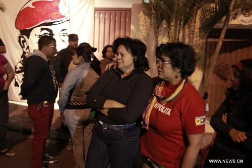 Residents react in front of the Venezuelan Embassy to Honduras after the news of Venezuelan President Hugo Chavez's death was released, in Tegucigalpa, Honduras, on March 5, 2013. Venezuelan President Hugo Chavez died on March 5. (Xinhua/Pedro Mera)