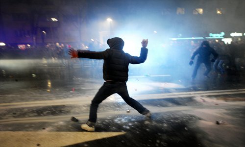 A demonstrator throws a rock at riot police during clashes on the sidelines of a protest against the government in Sofia on Tuesday. Bulgaria's prime minister announced Wednesday the surprise resignation of his government after days of sometimes violent rallies. Bulgaria has been shaken over by protests that initially were about soaring electricity prices but which have turned into demonstrations against the government in general. Photo: AFP