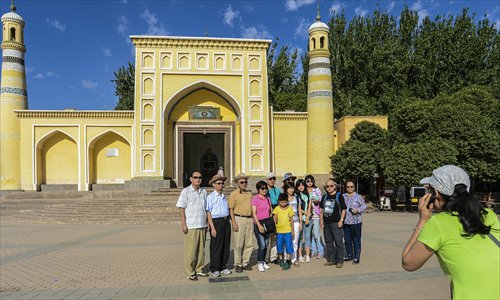 A group of tourists from Taiwan have their pictures taken in front of the Id Kah Mosque, the largest in China, in Kashi, Xinjiang Uyghur Autonomous Region on Friday. A foreign ministry spokeswoman said on Friday that recent riots in the autonomous region were terrorist attacks that disturbed the normal social order and that governments at all levels have made effective efforts to ensure security for residents. Photo: Xinhua