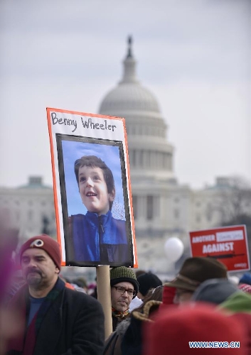 People hold the picture of Benny Wheeler, a victim of the Sandy Hook school shooting, in front of the Capitol Hill during a march in Washington D.C., capital of the United States, Jan. 26, 2013. Thousands of people, including family members of victims and survivors of shootings at Virginia Tech University, Sandy Hook elementary school and others, took part in a march for stricter gun control laws here on Saturday. (Xinhua/Zhang Jun) 