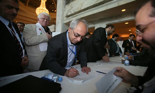 Syrian National Council (SNC) chief Abdel Basset Sayda (center) registers to vote for new members in the SNC's general secretariat during a meeting in the Qatari capital Doha on Wednesday. Photo: AFP 