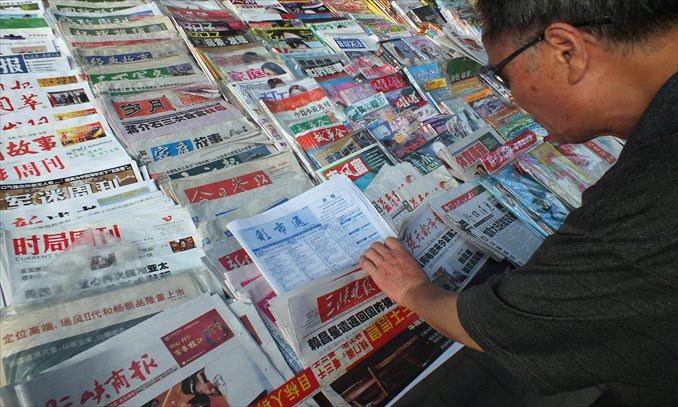A man leafs through newspapers at a newsstand in Yichang, Hubei Province. Photo: CFP