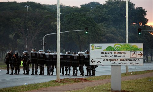 Riot police block a road during protests by Brazilian social movement activists and indigenous people against the upcoming FIFA World Cup in Brasilia on Tuesday.