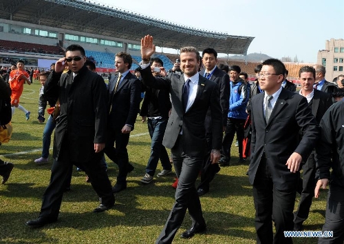British soccer player David Beckham (C) arrives at the Qingdao Tiantai Stadium in Qingdao, east China's Shandong Province, March 22, 2013. Beckham visited Qingdao Jonoon Soccer Club as the ambassador for the youth football program in China and the Chinese Super League Friday. (Xinhua/Li Ziheng) 