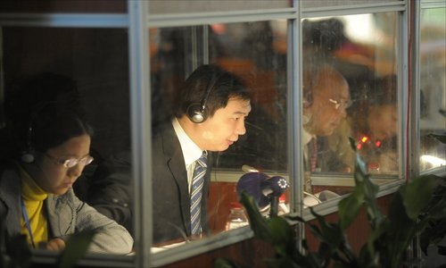 Simultaneous interpreters working inside a booth in a corner at a conference hall Photo: CFP