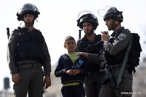 Israeli forces arrest a Palestinian youth in the eastern Jerusalem's Arab neighbourhood of Silwan on Jan. 28, 2013. Nine people were injured and seven arrested in Silwan after clashes broke out as Israeli forces demolished several structures. (Xinhua/Muamar Awad) 