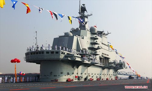 Military officers stand onboard China's aircraft carrier 