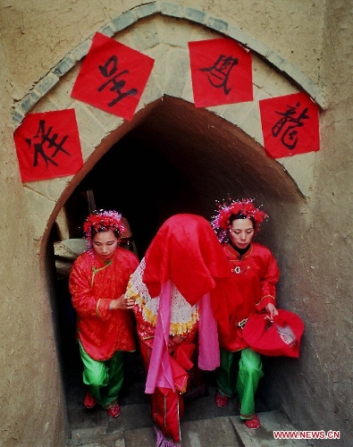 &nbsp;A bride (C) with a red cloth on the head walks along a corridor to her wedding ceremony in Zhangbian Township of Shanxian County, central China's Henan Province, Feb. 9, 2000. People who live in the central China region usually hold wedding ceremonies during the festive Spring Festival period. (Xinhua/Wang Song) 