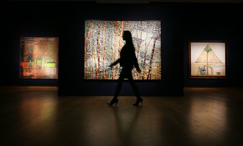 An employee walks past works sold at Christie's Post War and Contemporary Art sale in London on February 8. Photo:CFP