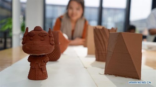 A visitor views pottery craftworks made by 3D printer in Jingdezhen, east China's Jiangxi Province, Oct. 19, 2016. (Photo/Xinhua)