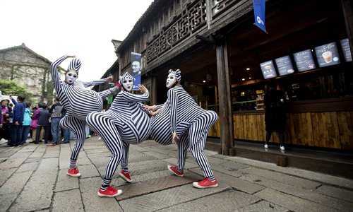 Street performers pose for a photo during the Wuzhen Theatre Festival in October in Wuzhen, Zhejiang Province. Photo: Courtesy of Wuzhen Tourism Co., Ltd