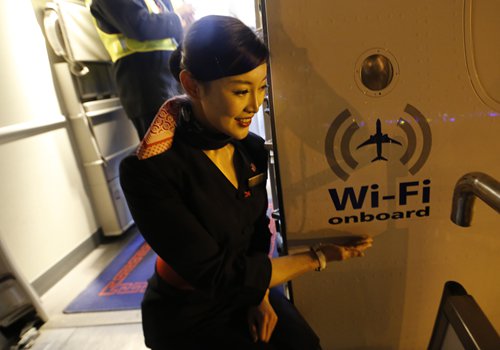 An air stewardess stands by a Wi-Fi logo on a Chinese Eastern Airlines flight in January in Qingdao, East China's Shandong Province. Photo: CFP 