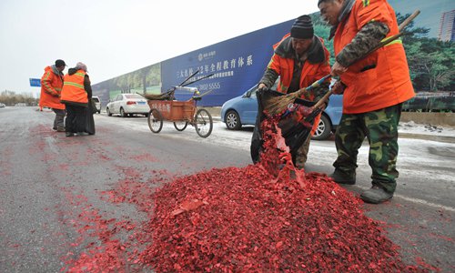 Street cleaners dispose of garbage from firecrackers in Shenyang, Liaoning Province. Photo: CFP
