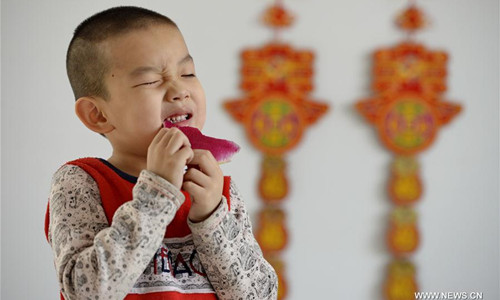 A young boy eats radish to celebrate Lichun, literally the beginning of spring in Chinese, at a kindergarten in Xingtai City, north China's Hebei Province, Feb. 3, 2017. Lichun, the first of the 24 solar terms, fell on Feb. 3 this year. Chinese usually eat radishes or spring pancakes to celebrate the day. (Xinhua/Mou Yu)