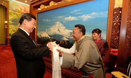 Xi Jinping (left), general secretary of the Central Committee of the Communist Party of China (CPC), receives a hada, a white silk scarf symbolizing respect and blessing, from a deputy to the 12th National People's Congress (NPC) from southwest China's Tibet Autonomous Region, in Beijing, capital of China, March 9, 2013. Xi joined a discussion with the Tibet delegation attending the first session of the 12th NPC in Beijing on Saturday. Photo: Xinhua