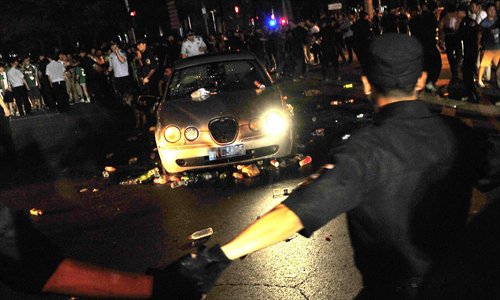 Police cordon off a car that was attacked by Guo’an fans outside the Workers’ Stadium Saturday night. Photo: Osports Photo Agency
